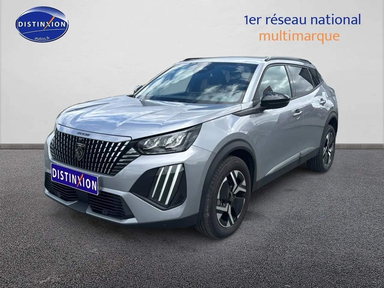 Peugeot 2008 gris artense en 3/4 avant droit avec calandre distinctive et jantes alu bicolores.