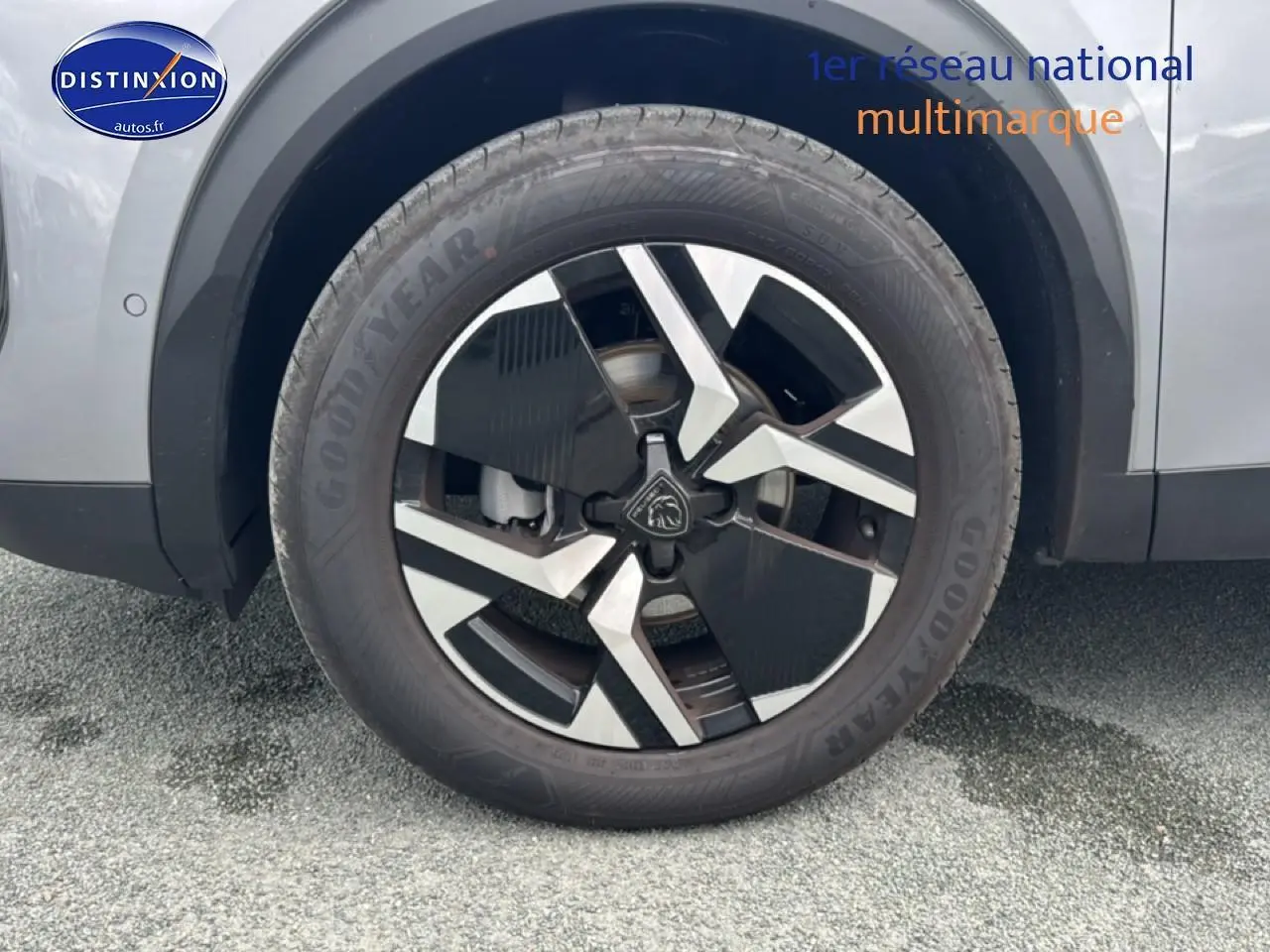 Gros plan sur la roue avant gauche du Peugeot 2008 gris Artense avec jante alu au design moderne.
