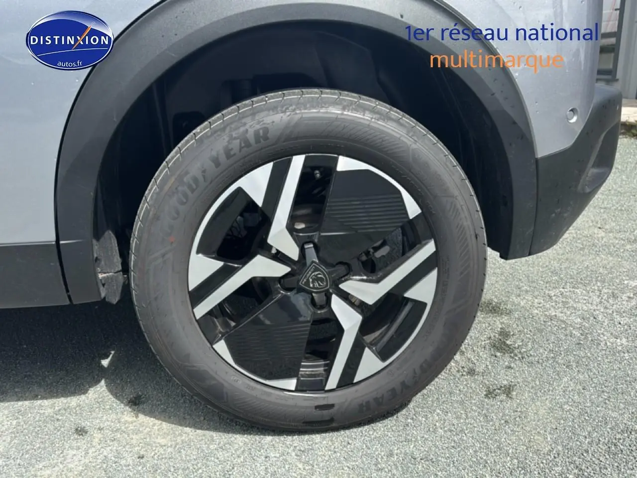 Gros plan sur la roue avant droite du Peugeot 2008 1.2 100 allure gris artense avec jante alu bicolore.