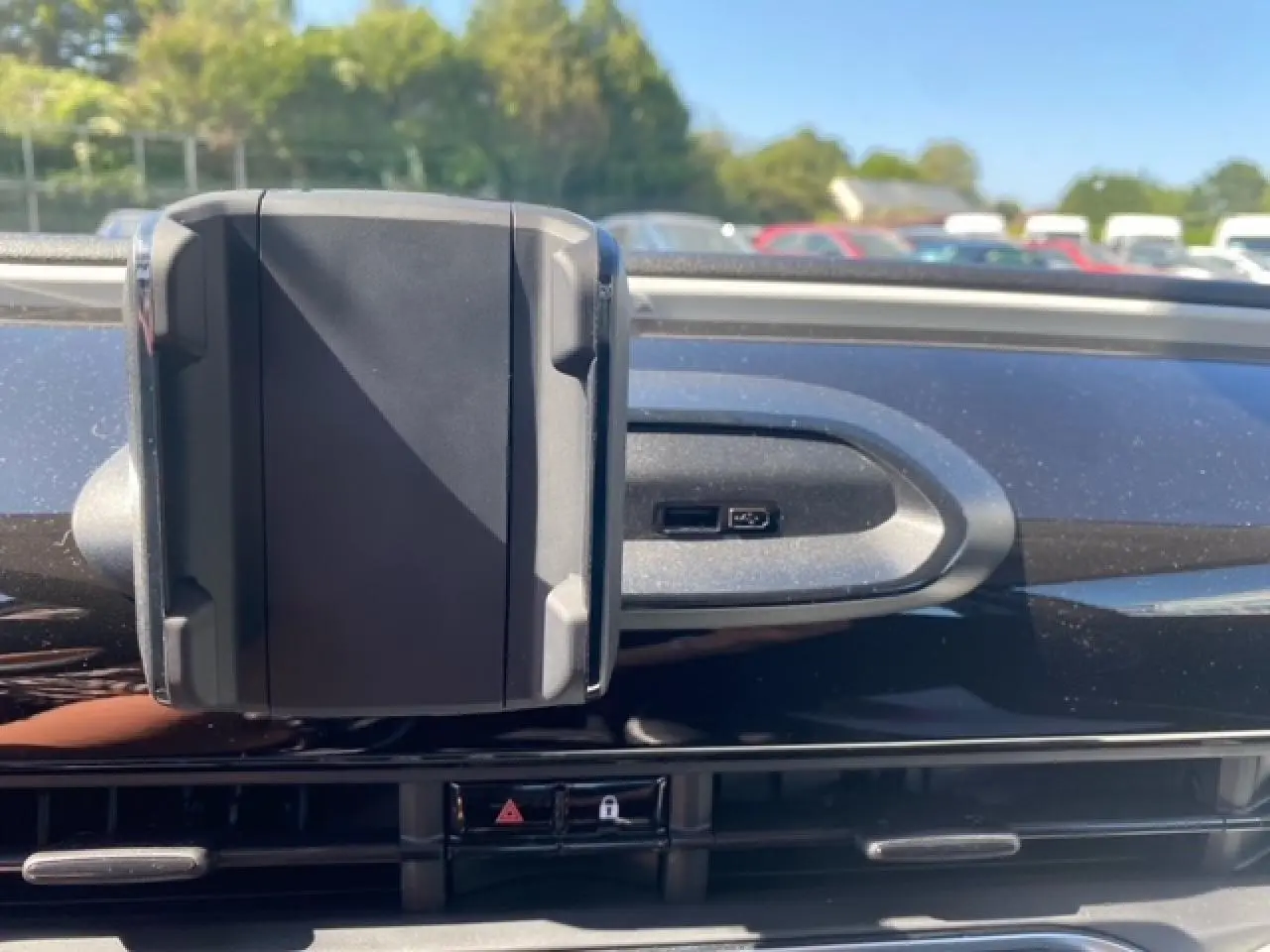 Support smartphone fixé sur la planche de bord noire de la Fiat 500 électrique vue de face en intérieur.