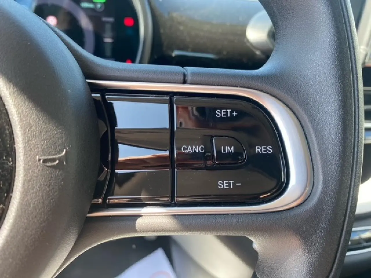Gros plan sur les commandes de régulateur de vitesse au volant d'une FIAT 500 électrique blanche, version 2022.