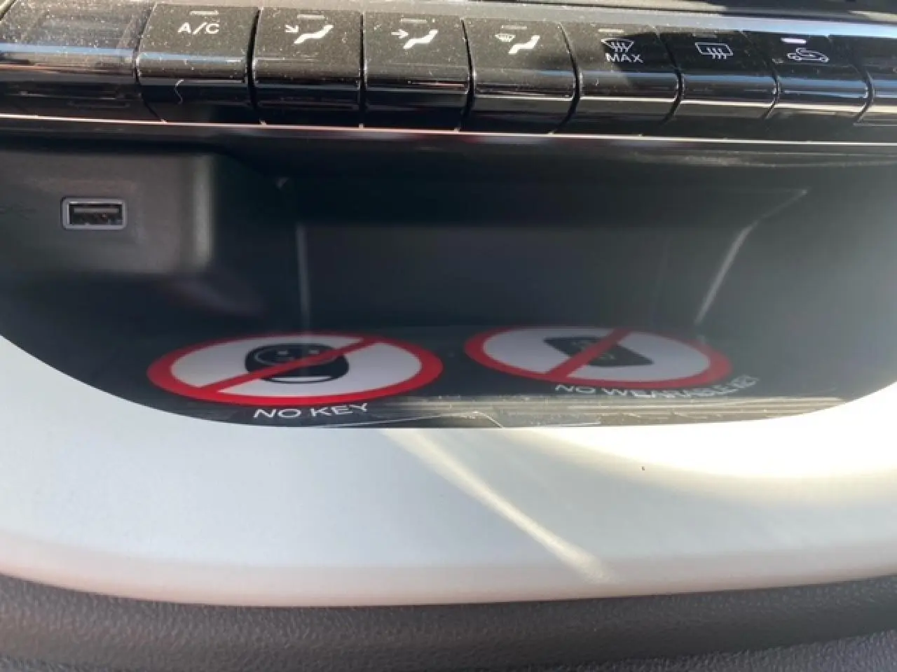 Vue rapprochée de la console centrale blanche de la Fiat 500 électrique 2022 avec boutons de climatisation et port USB visible.