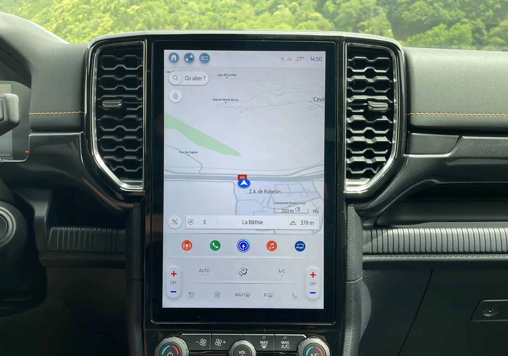 Vue frontale du tableau de bord du Ford Ranger Wildtrak 2026 gris carbone, avec écran tactile GPS vertical et aérateurs hexagonaux.