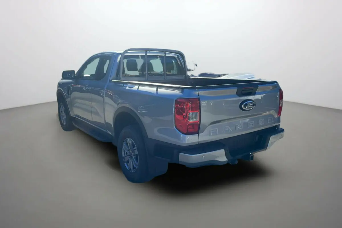 Ford Ranger gris iconic en 3/4 arrière droit, avec benne ouverte et barres de protection arrière visibles.
