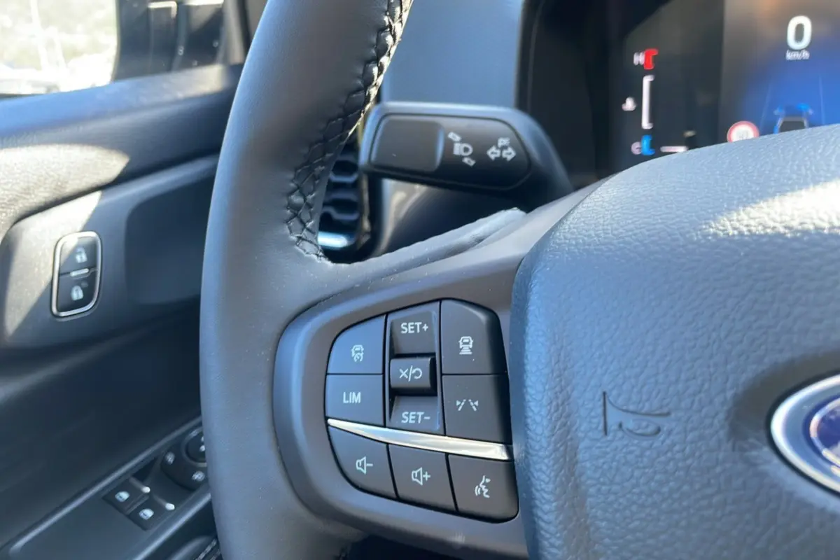 Gros plan sur le volant cuir multifonctions du Ford Ranger gris iconic, avec commandes audio et régulateur de vitesse.