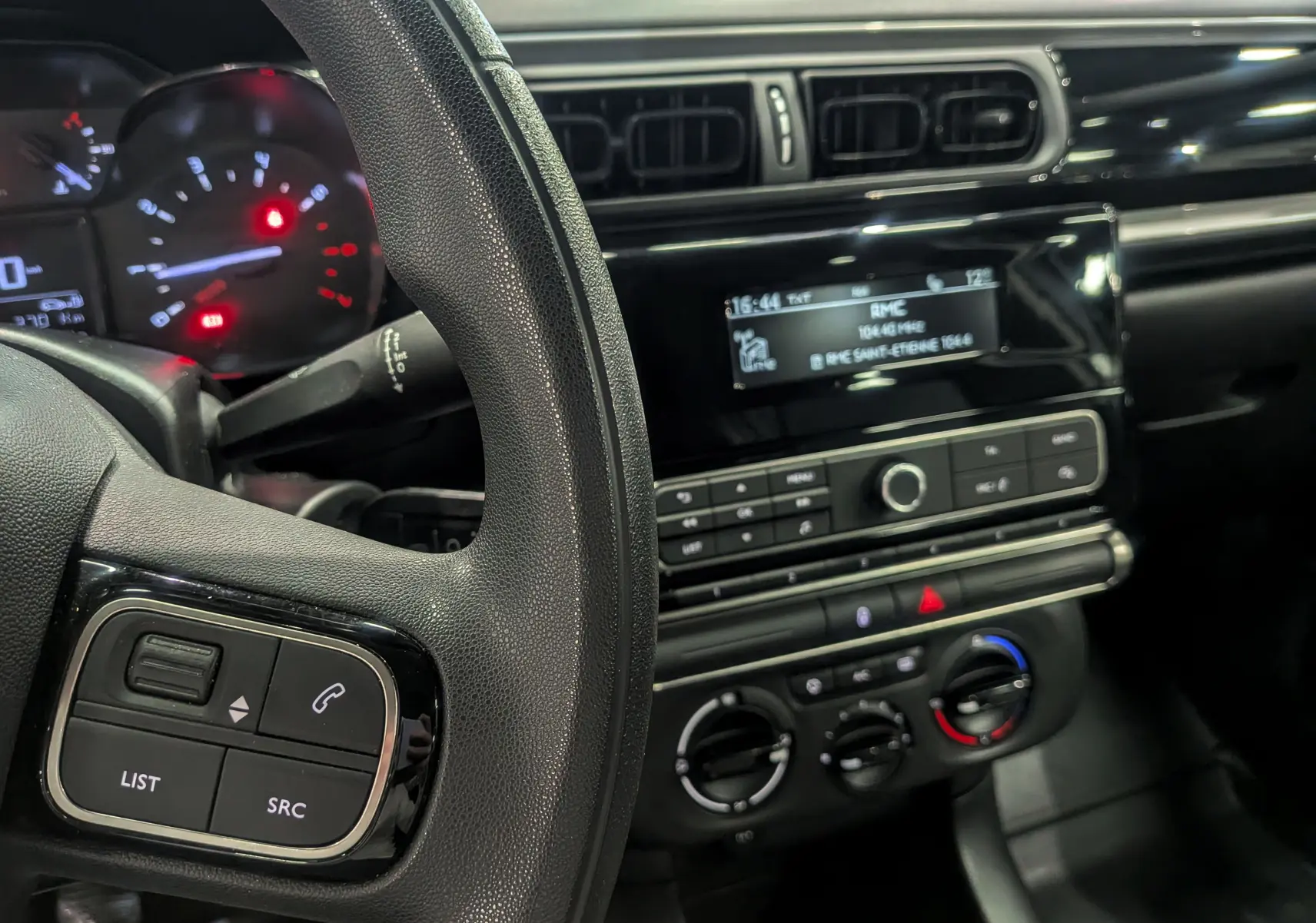 Vue intérieure centrée sur le volant et la console centrale noire de la Citroën C3 Société 2019.