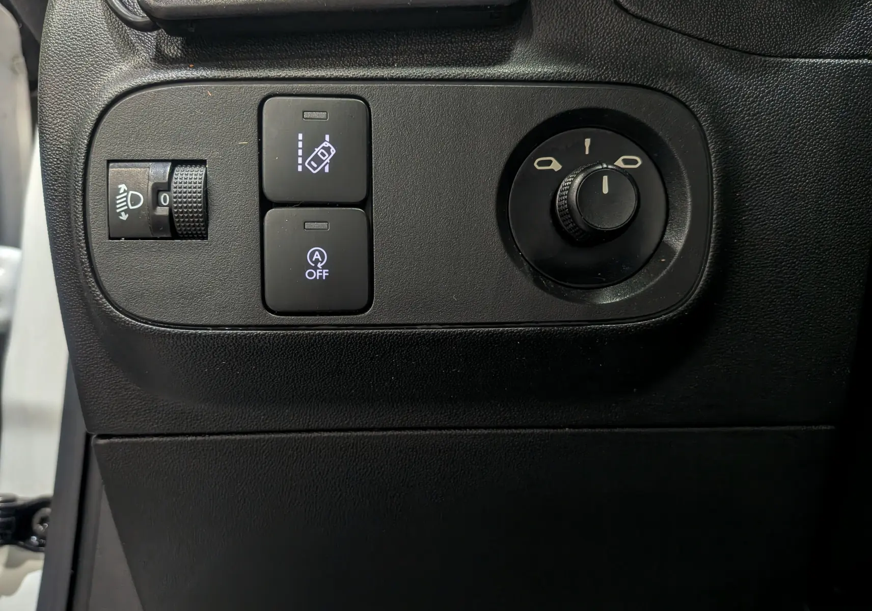 Gros plan sur les commandes noires du tableau de bord côté gauche du Citroën C3 Société blanc Banquise 2019.