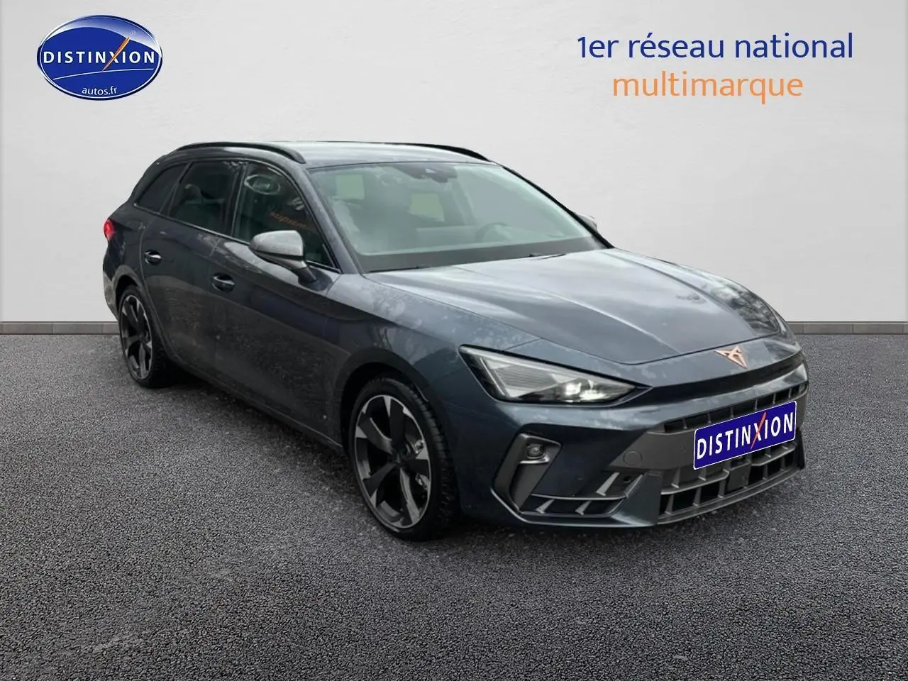 Vue 3/4 avant droite d'une CUPRA Leon ST gris magnétique avec jantes alliage noires et toit ouvrant.