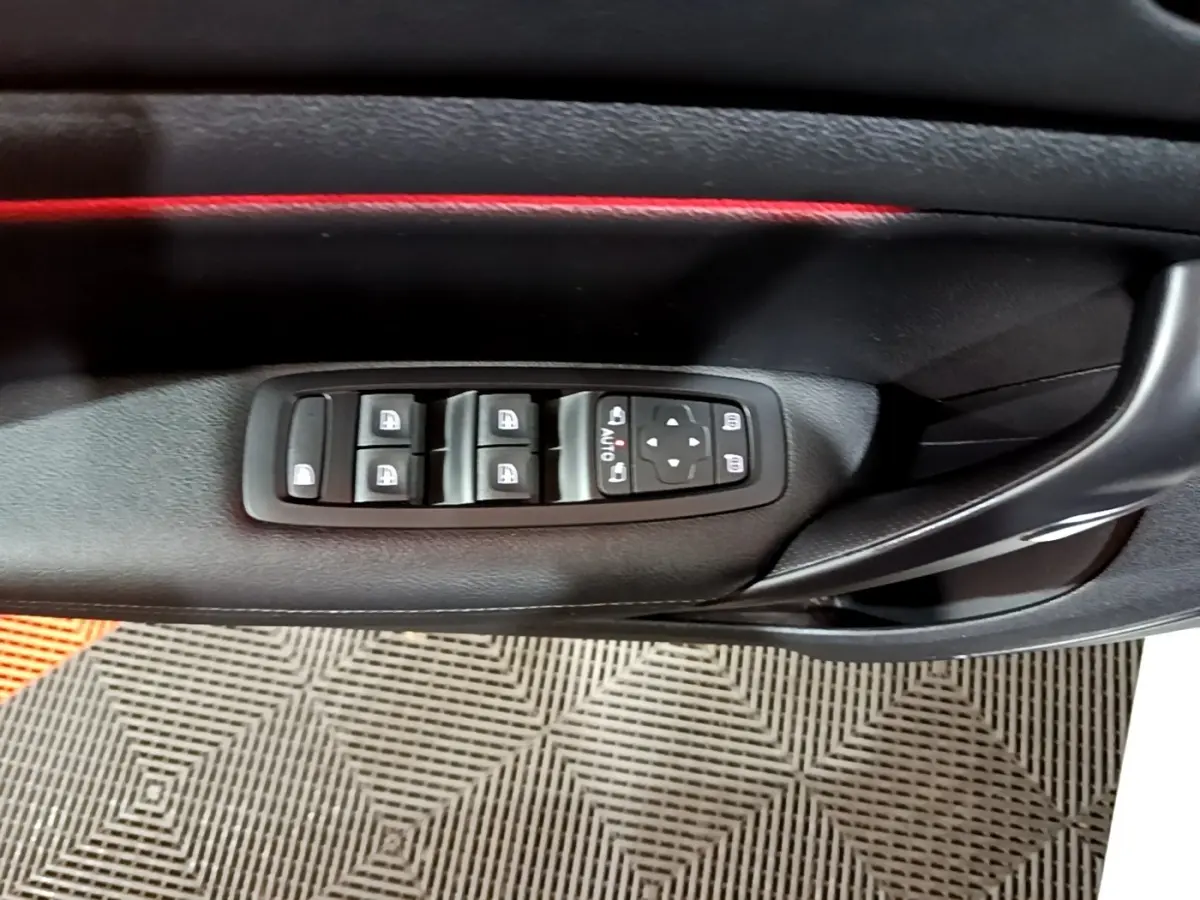 Détail des commandes de lève-vitres et rétroviseurs sur la porte côté conducteur de la Renault Mégane Techno blanche 2023.