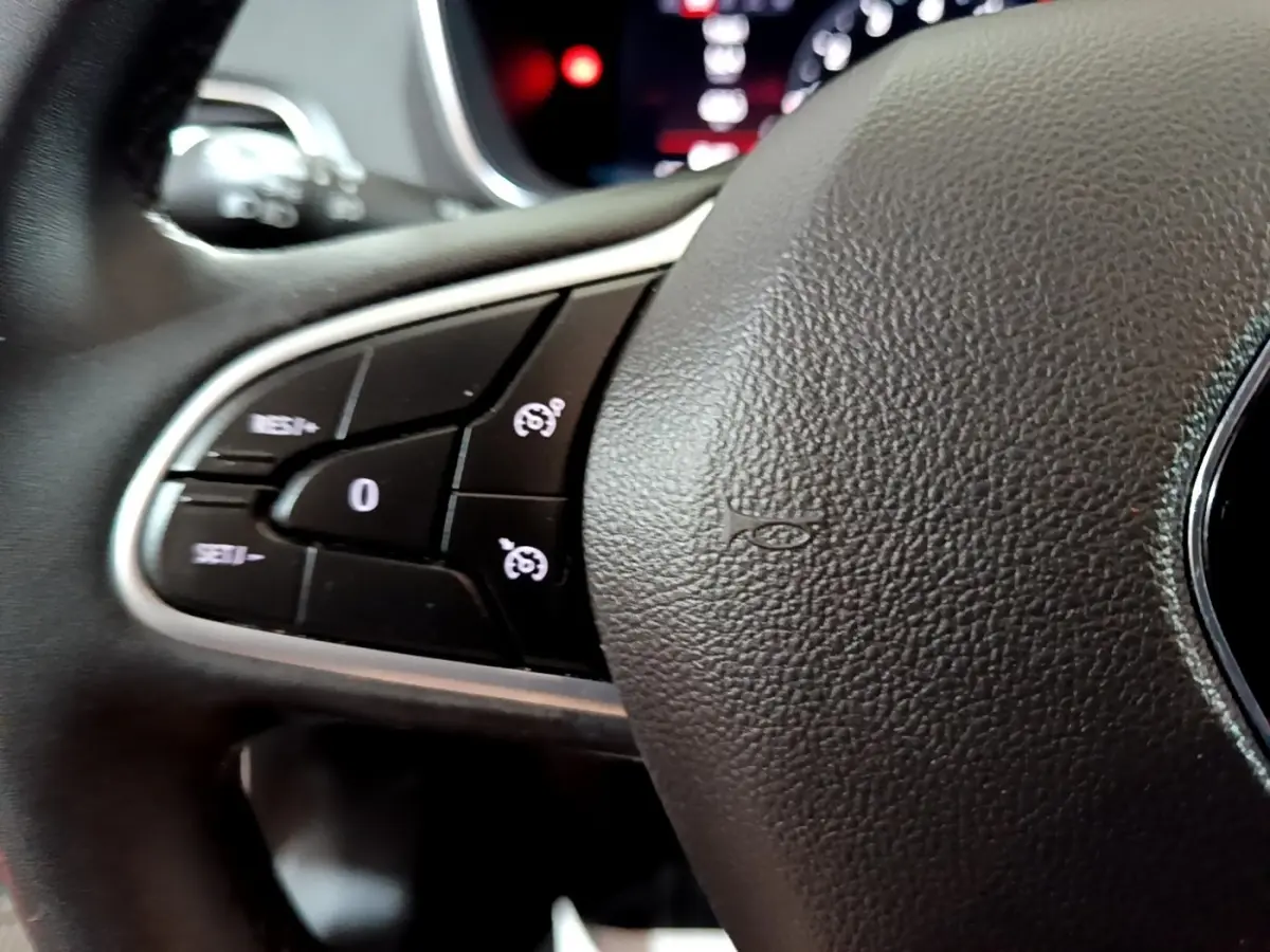 Gros plan sur les commandes du volant noir de la Renault Mégane Techno TCe 140 EDC 2023.