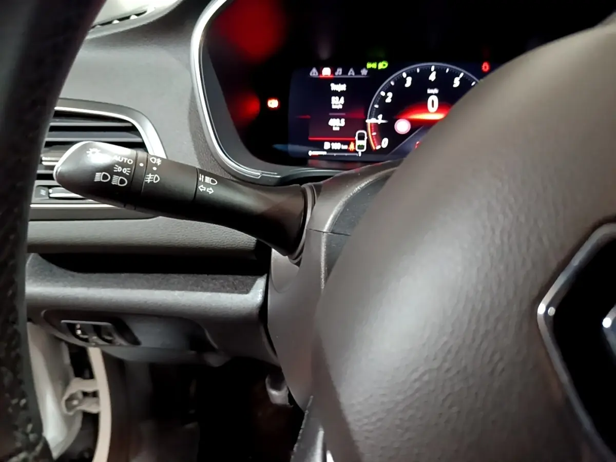 Vue rapprochée du tableau de bord et du volant de la Renault Mégane Techno TCe 140 blanc, avec affichage numérique rouge.