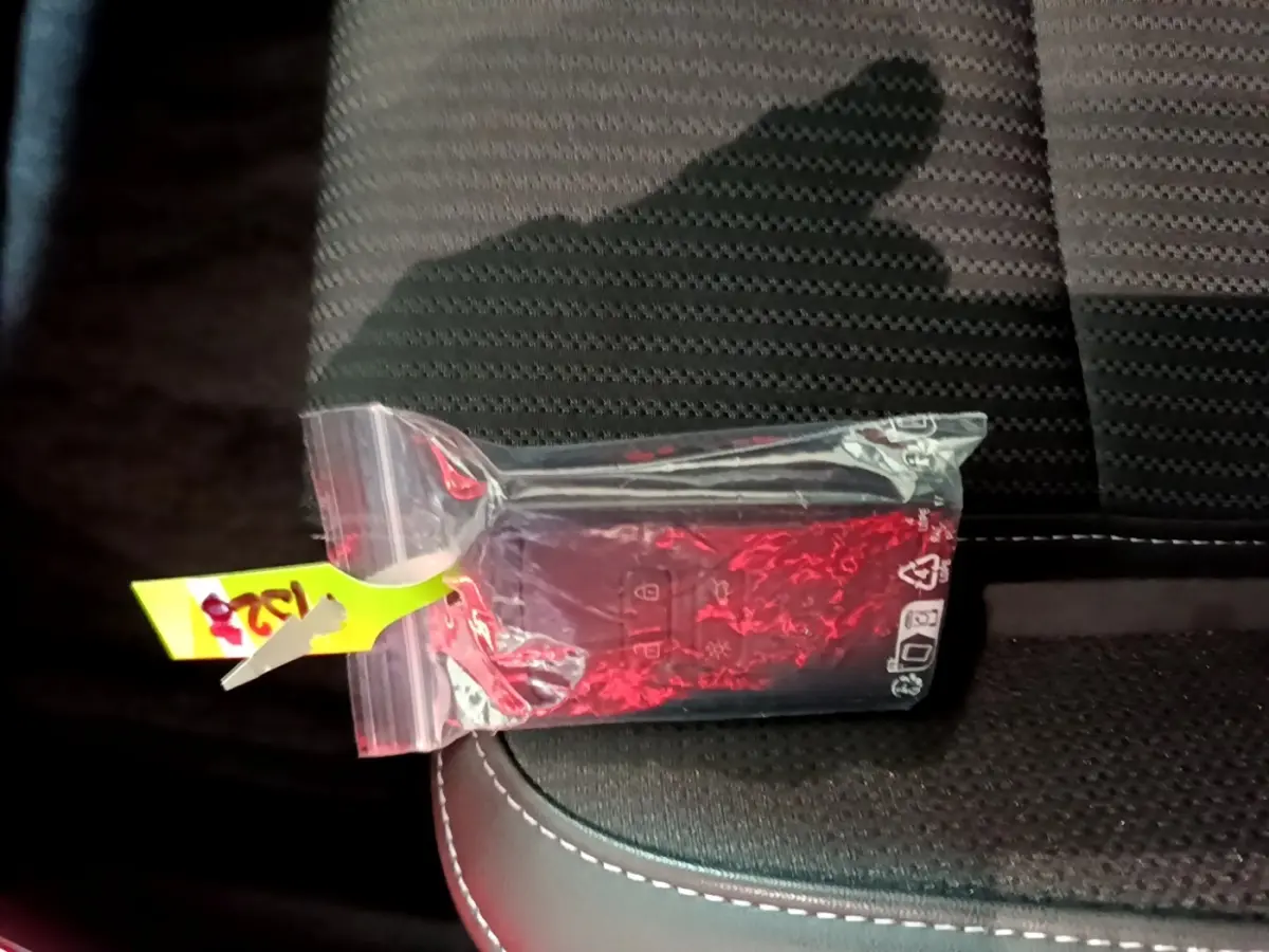 Télécommande Renault Megane Techno TCe 140 EDC 2023 emballée, posée sur siège tissu noir avec surpiqûres blanches.