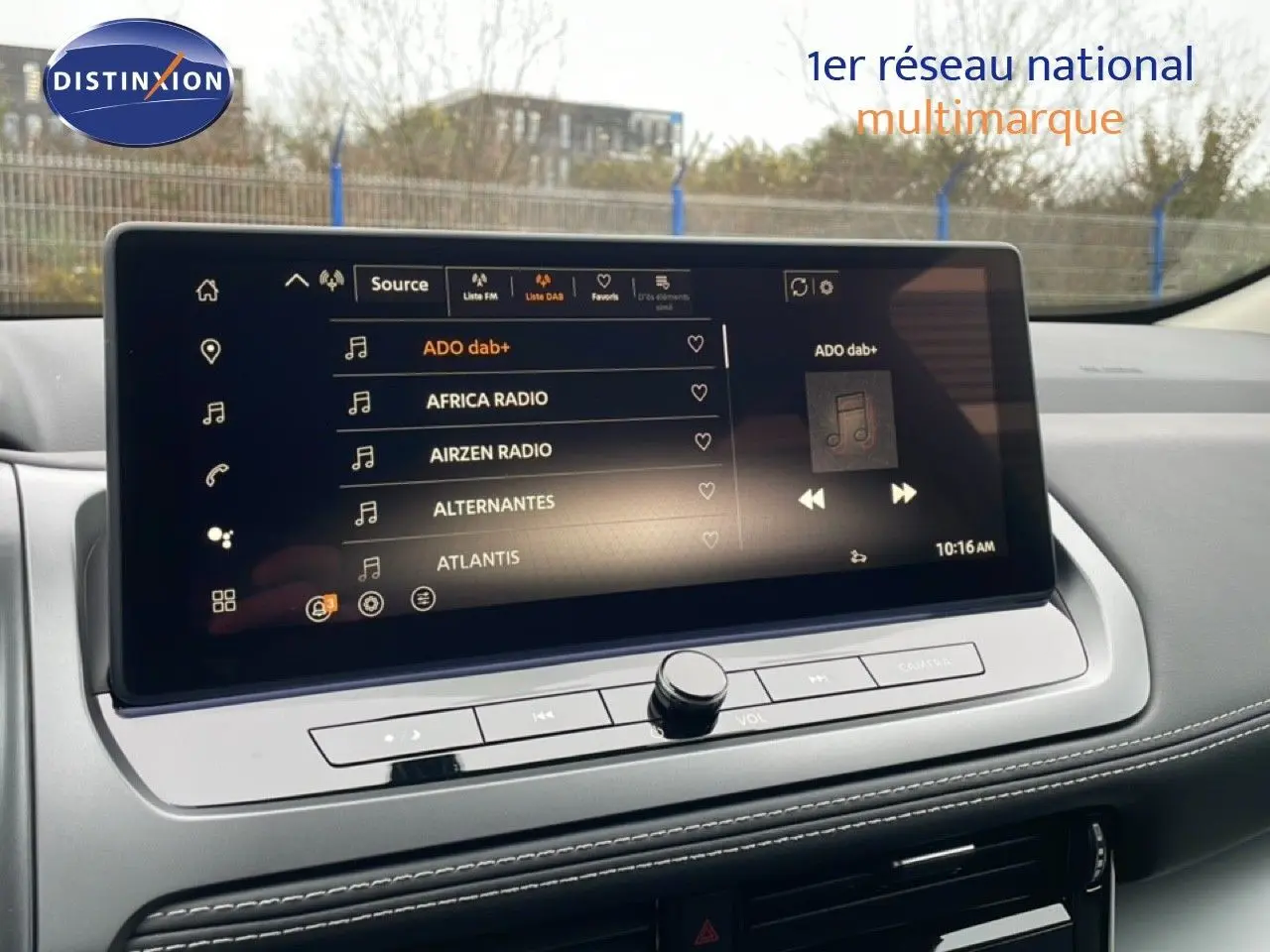 Écran tactile central du Nissan Qashqai 1.5 E-POWER 2025 affichant les stations radio, intérieur gris clair avec coutures blanches.