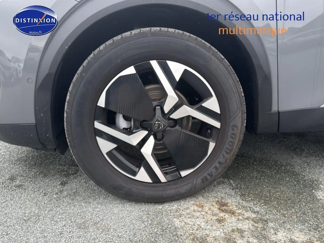 Gros plan sur la roue avant droite d’un Peugeot 2008 gris sélénite avec jante alu au design moderne.