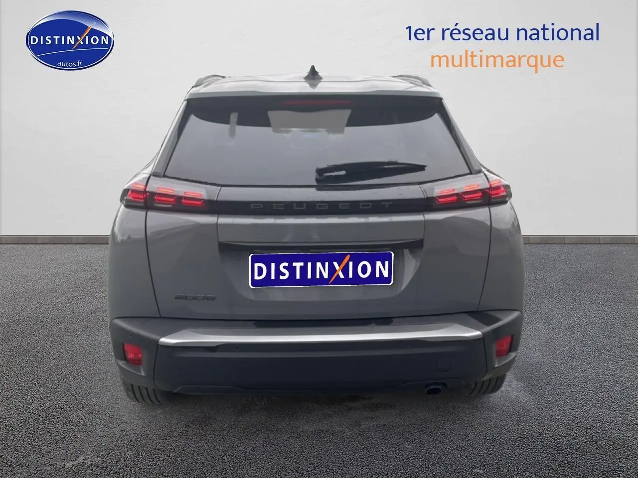 Vue arrière d'un Peugeot 2008 gris sélénite 2025 avec feux arrière à LED et becquet noir.
