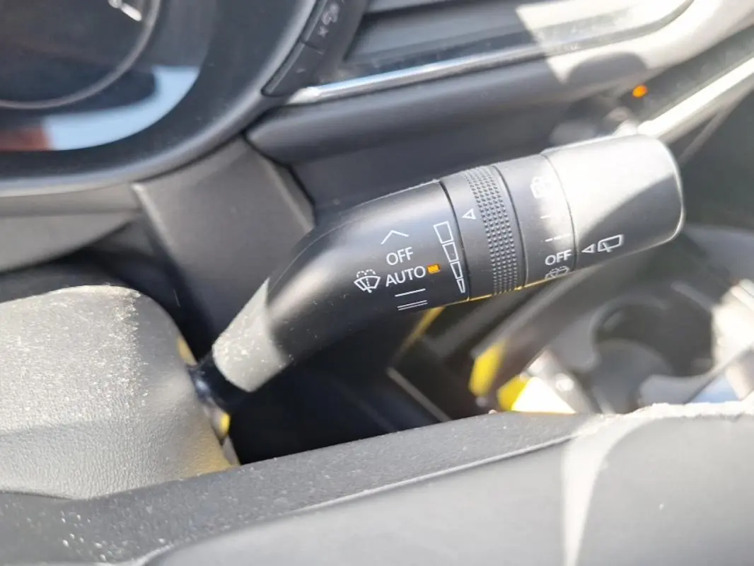 Gros plan sur la commande de l'essuie-glace côté droit du tableau de bord d’un Mazda CX-30 gris 2020.