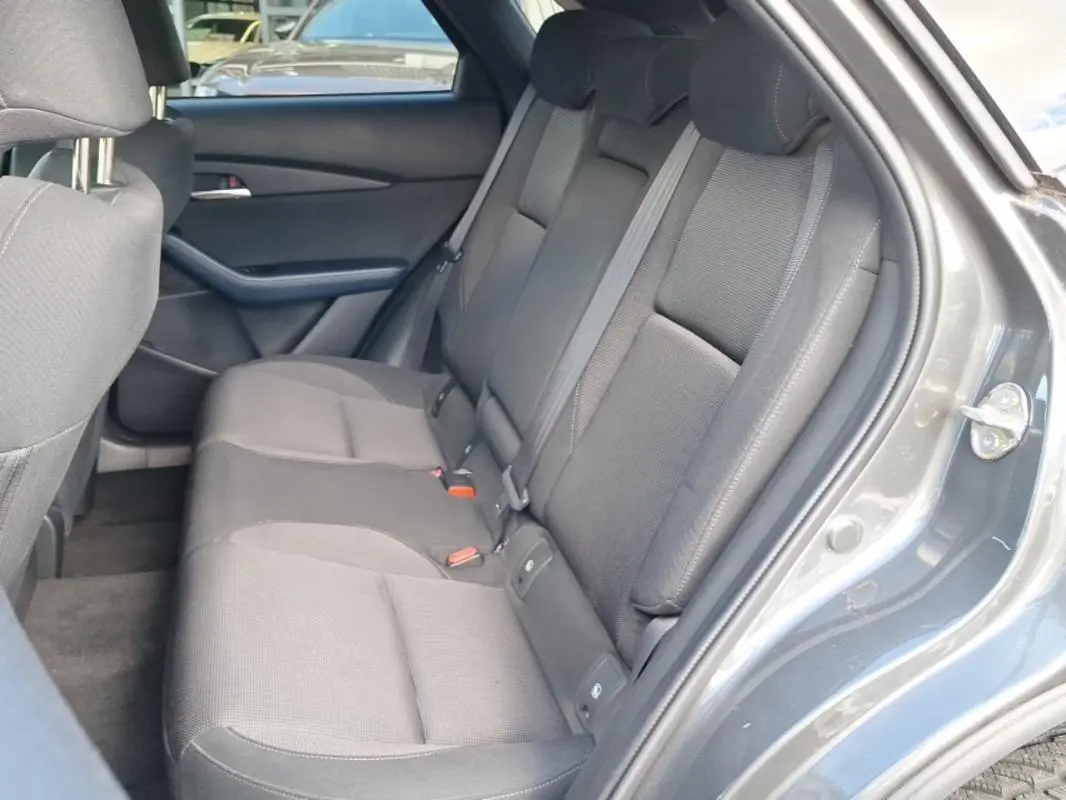 Vue intérieure côté droit des sièges arrière gris foncé du Mazda CX-30 2020 avec porte ouverte et garnitures assorties.