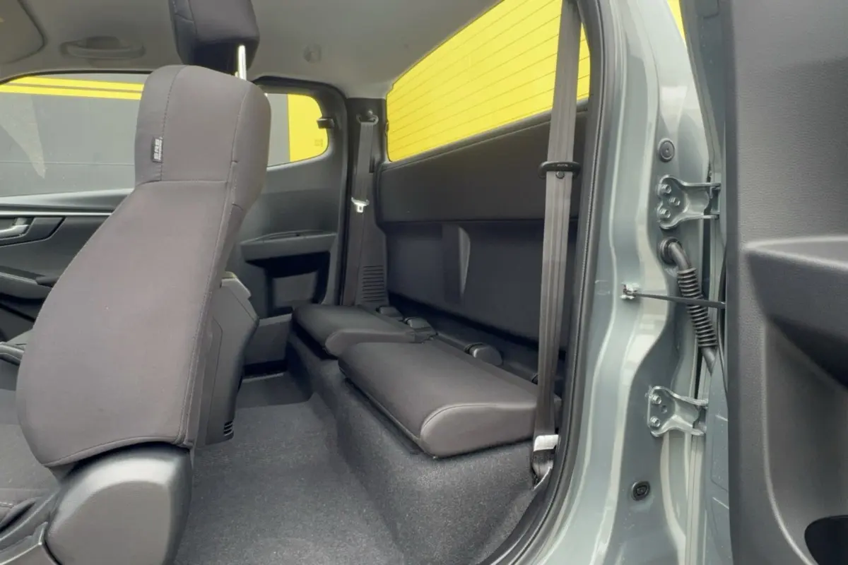Vue intérieure côté droit du pick-up Isuzu D-MAX 2026 Inishmore green, montrant la banquette arrière et la porte ouverte.