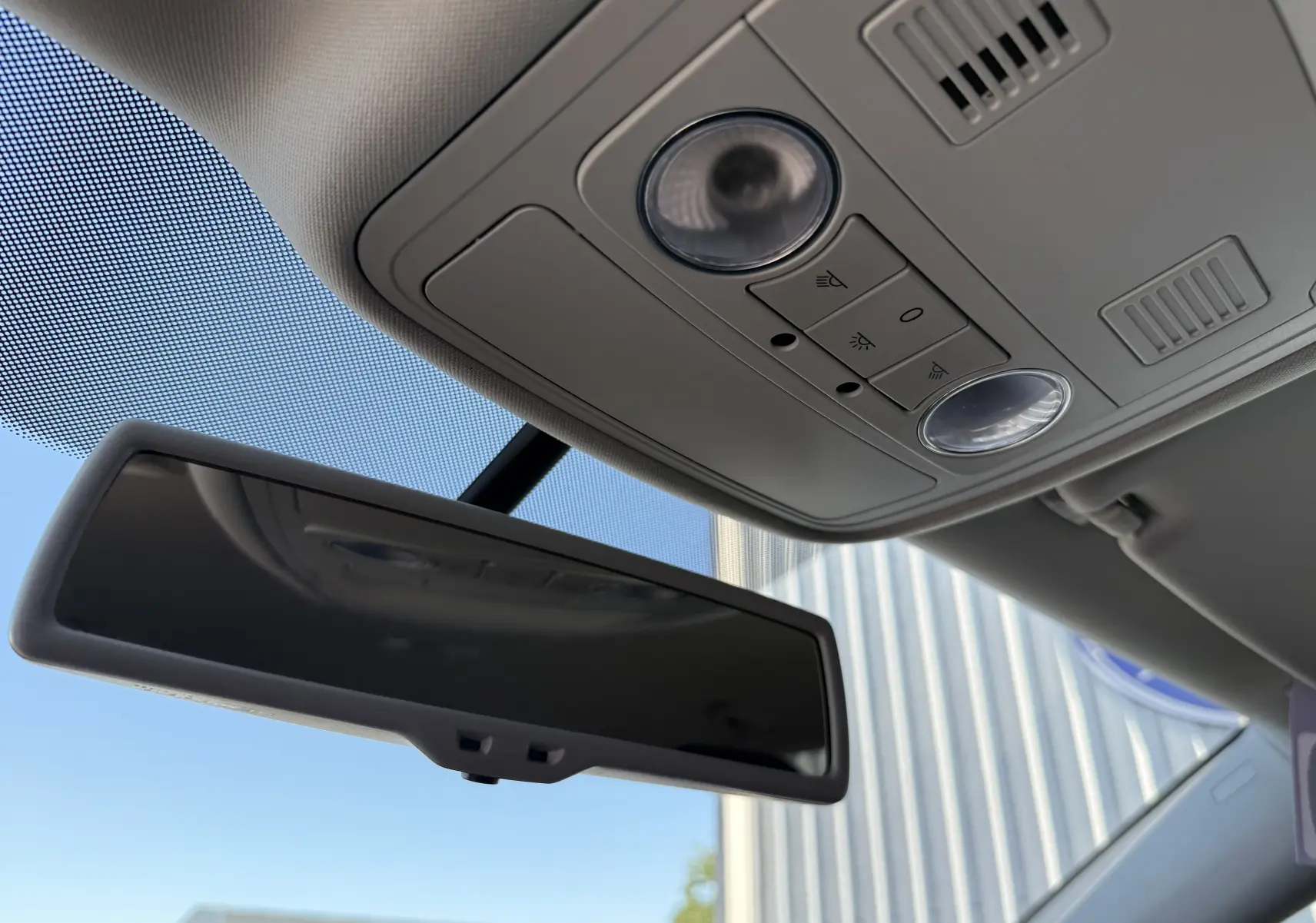 Vue intérieure du rétroviseur et plafonnier gris clair du Volkswagen Touran 2012, avec commandes d'éclairage intégrées.