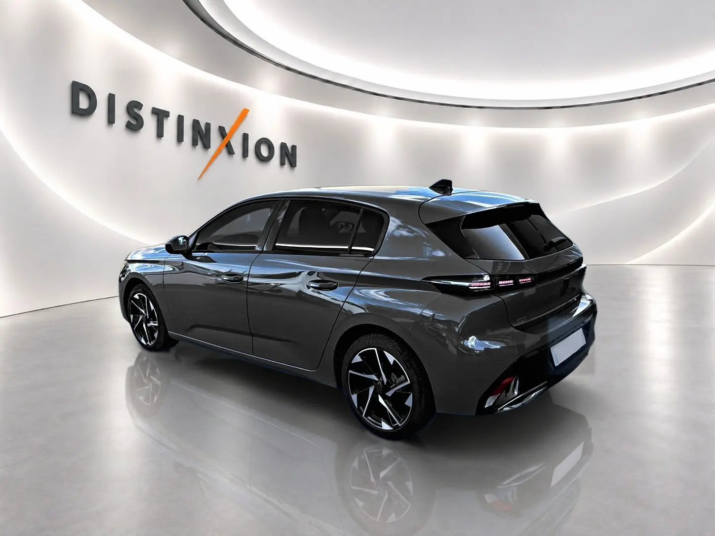 Peugeot 308 gris selenium vue 3/4 arrière droit, jantes alliage noires et feux arrière LED distinctifs.