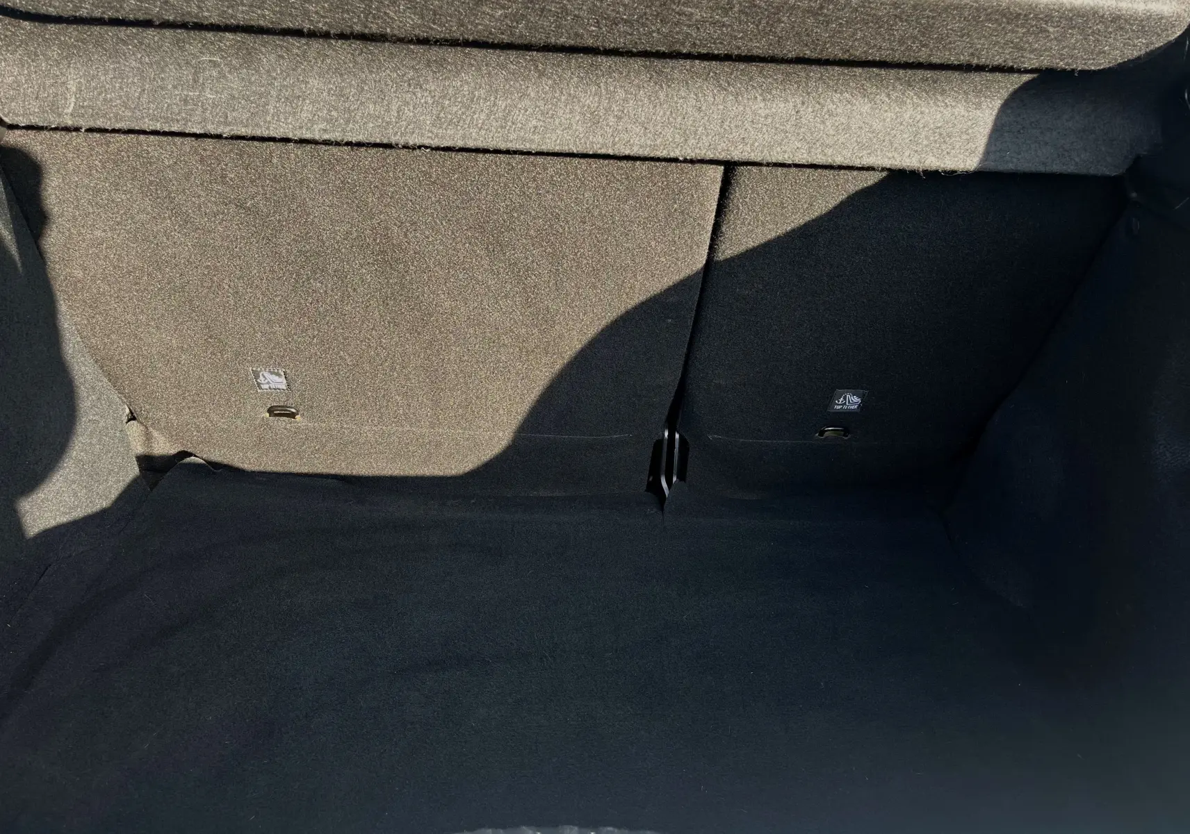 Coffre vide en tissu noir de la Citroën C3 blanche 2019, vue intérieure depuis l'ouverture arrière.