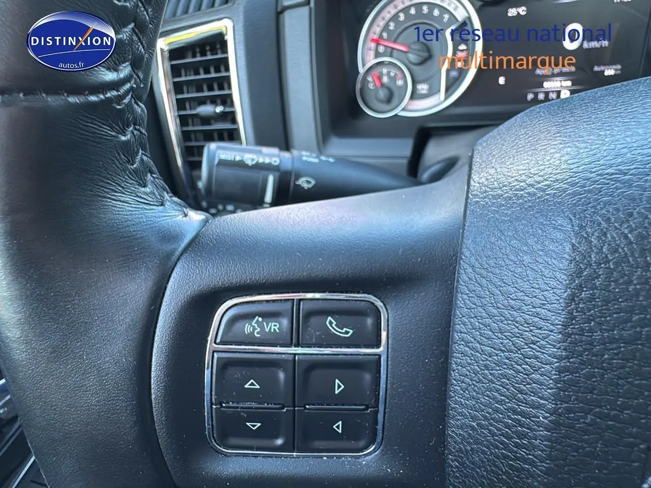 Gros plan sur le volant noir du Dodge RAM 2020 montrant les commandes vocales et téléphone côté gauche.