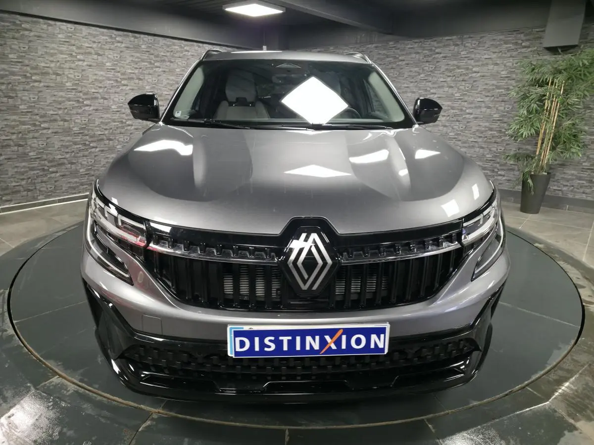 Vue frontale d'un Renault Espace gris avec calandre noire brillante et phares LED Matrix Vision allumés.