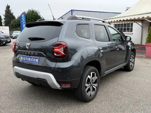 Vue 3/4 arrière droite d’un Dacia Duster 2022 gris comète avec feux LED et jantes alliage distinctives.