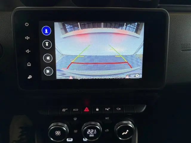 Écran de caméra de recul affichant l’arrière du Dacia Duster gris Comète avec les lignes de guidage colorées.