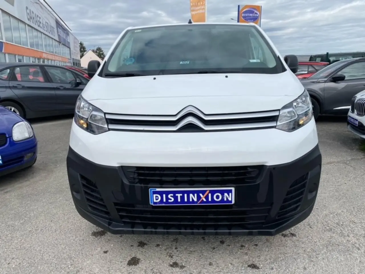 Vue avant d'un utilitaire Citroën Jumpy blanc avec pare-chocs noir et plaque d'immatriculation Distinxion.