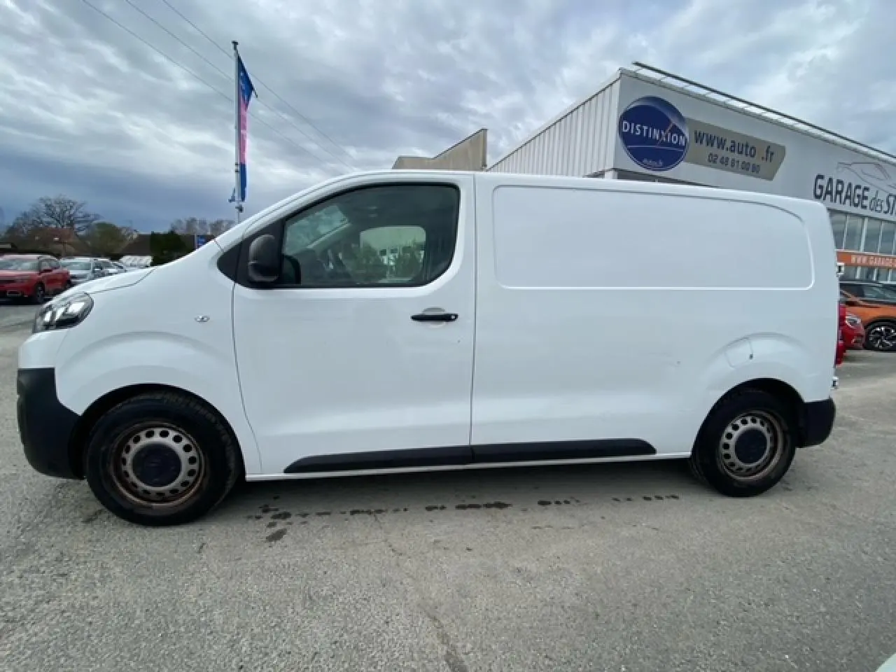 Vue de profil côté gauche d'un utilitaire Citroën Jumpy blanc, avec porte latérale coulissante et jantes acier noires.