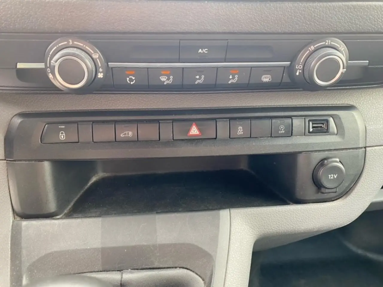 Vue rapprochée de la console centrale du Citroën Jumpy blanc 2019, avec commandes climatisation et boutons fonctionnels.