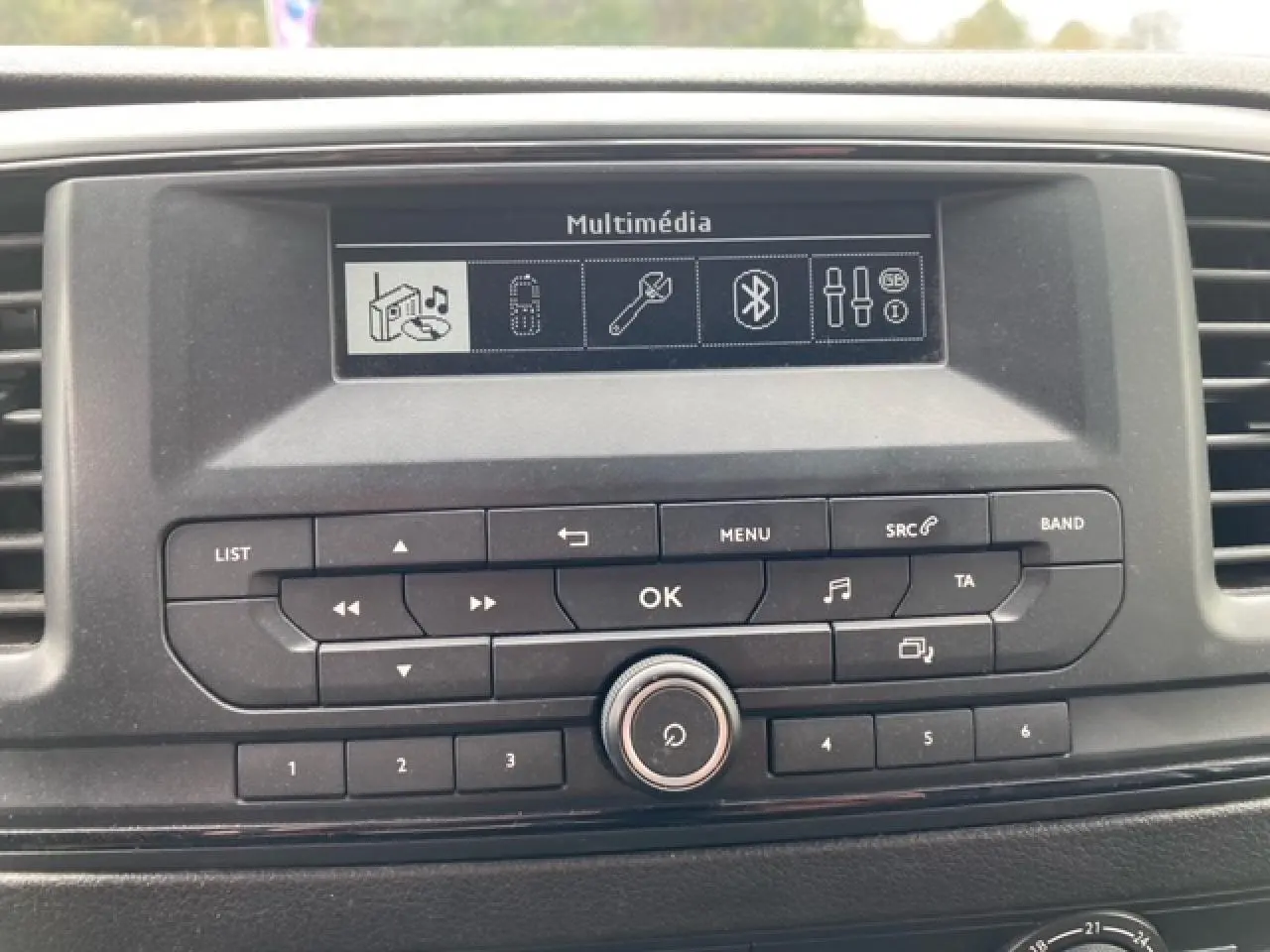 Gros plan sur la console centrale du Citroën Jumpy blanc de 2019, affichant l’écran multimédia et les commandes audio.