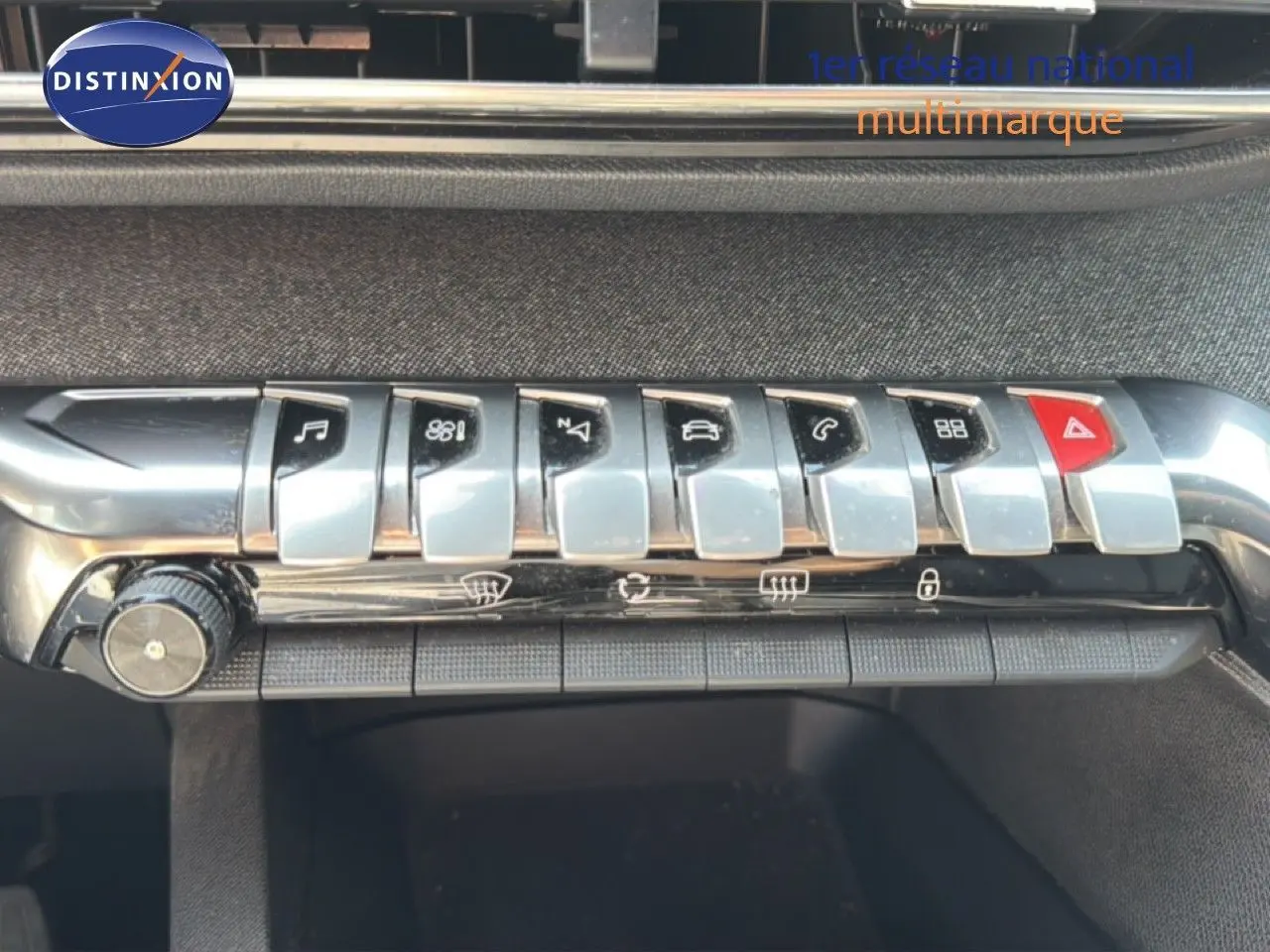 Gros plan sur la rangée de boutons chromés de la console centrale du Peugeot 5008 gris Platinium, version 2023.