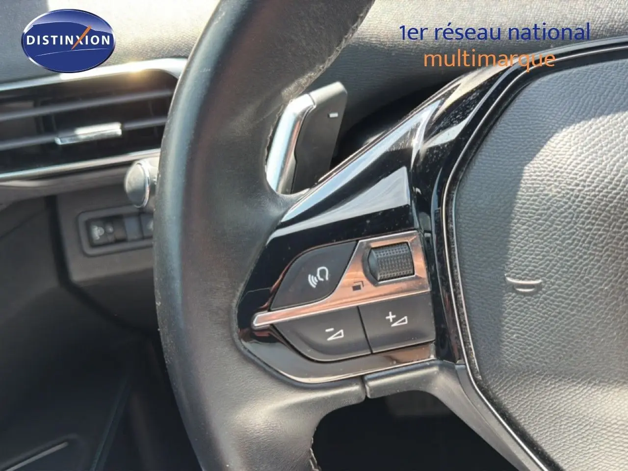 Gros plan sur les commandes gauche du volant cuir noir du Peugeot 5008 2023, finition Allure Pack.