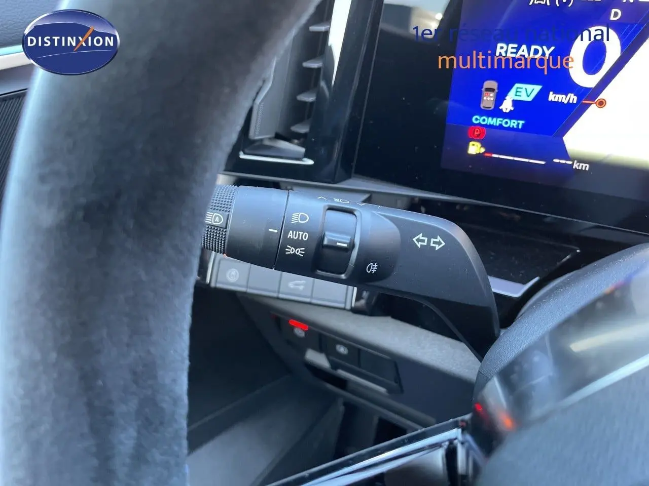 Vue intérieure du volant et du commodo d'éclairage du Renault Austral E-Tech noir étoile métal, avec tableau de bord digital visible.