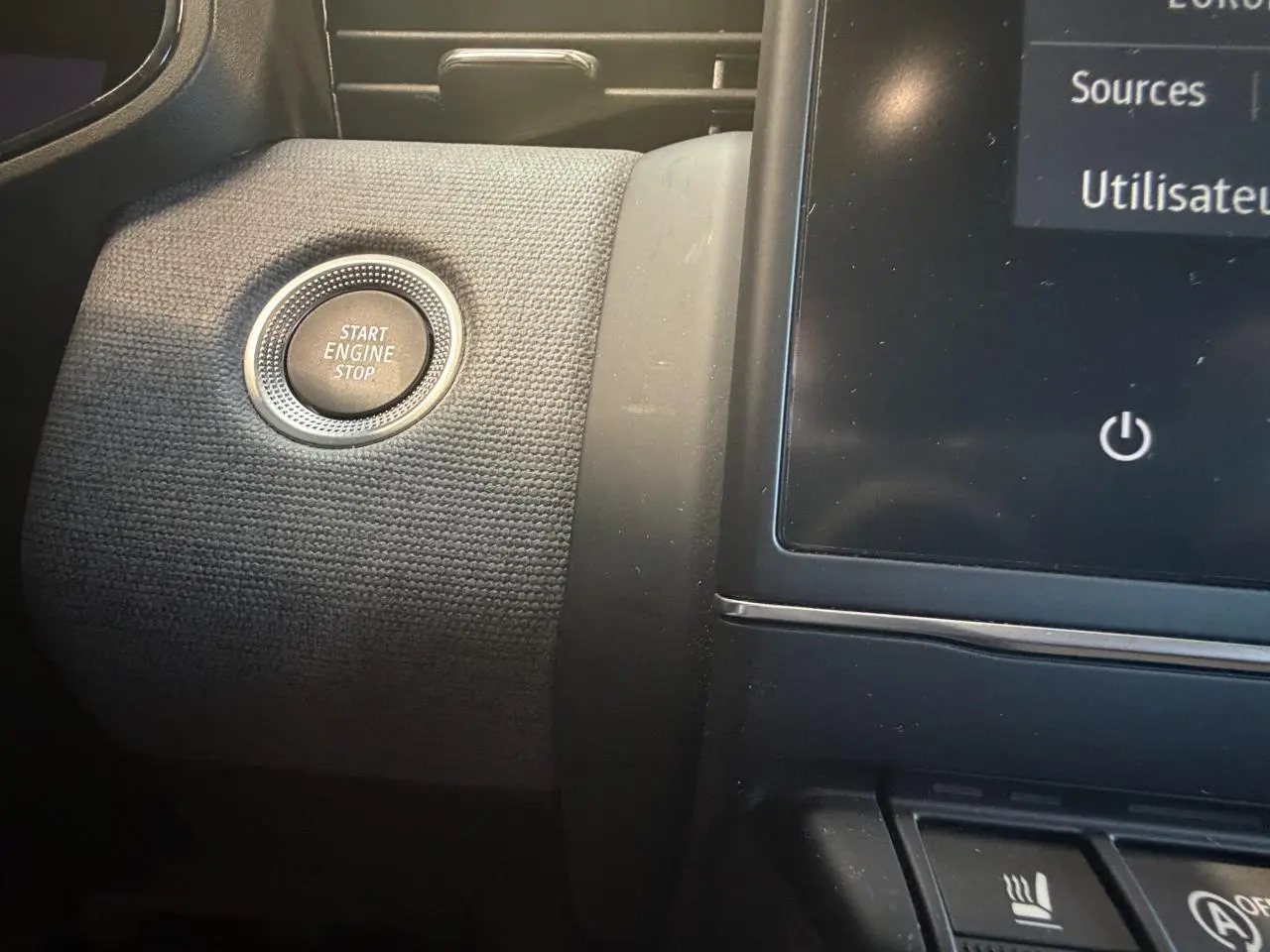 Détail intérieur du bouton Start Engine Stop sur la planche de bord noire texturée de la Renault Clio 2024.