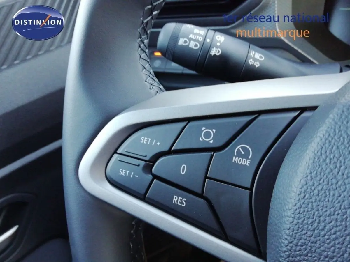 Gros plan sur les commandes au volant du Dacia Duster 2026, boutons de régulateur de vitesse et mode, finition gris schiste métal.