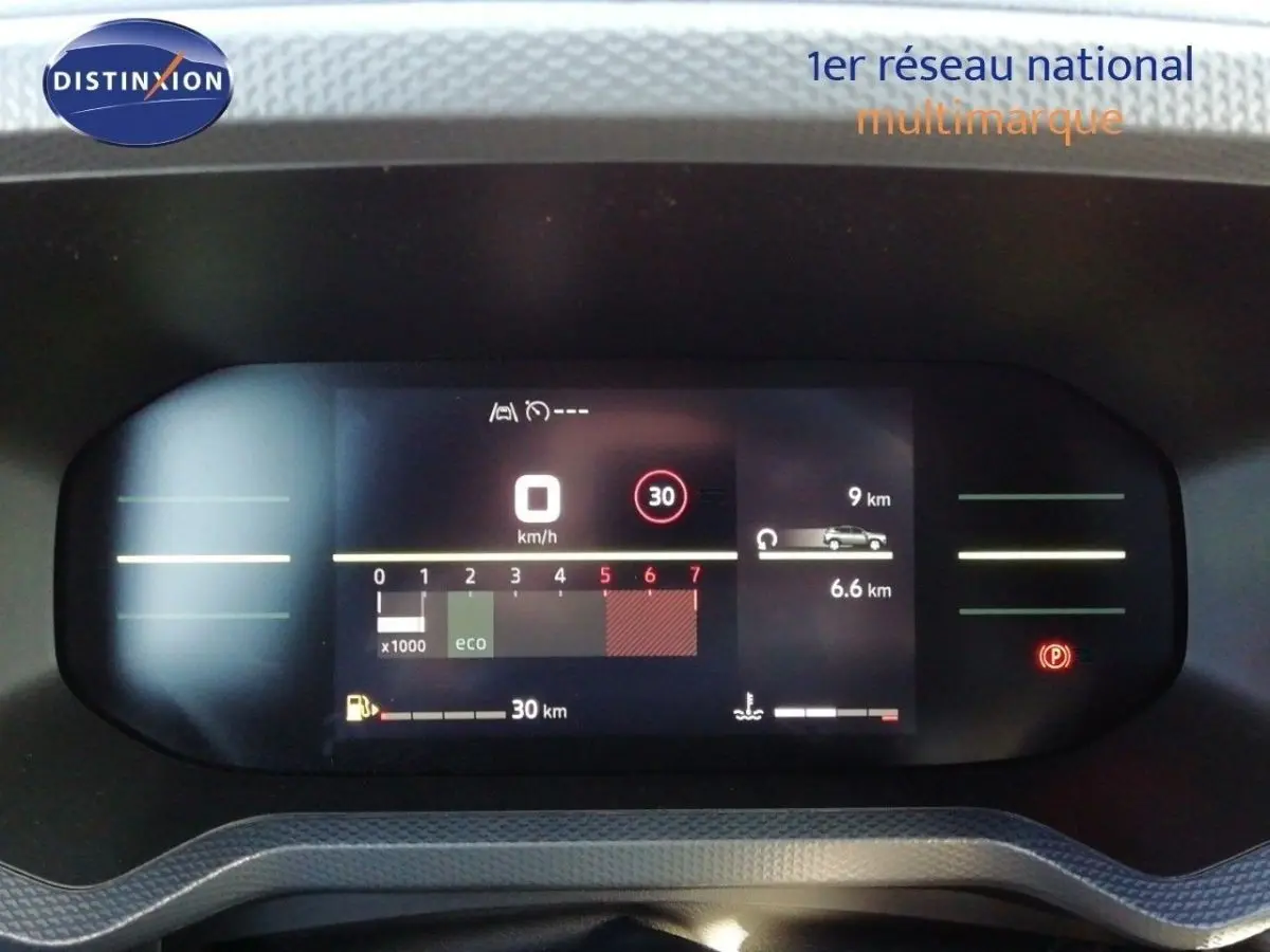 Tableau de bord numérique du Dacia Duster 2026 affichant la vitesse, régime moteur et autonomie, vue frontale rapprochée.