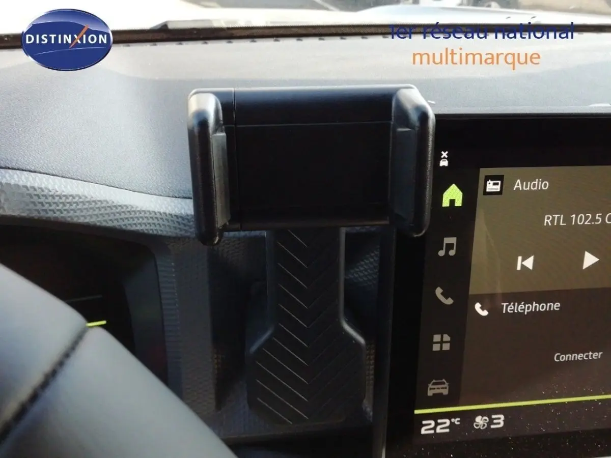 Vue intérieure centrée sur la console centrale du Dacia Duster gris schiste métal, avec écran tactile et support smartphone.