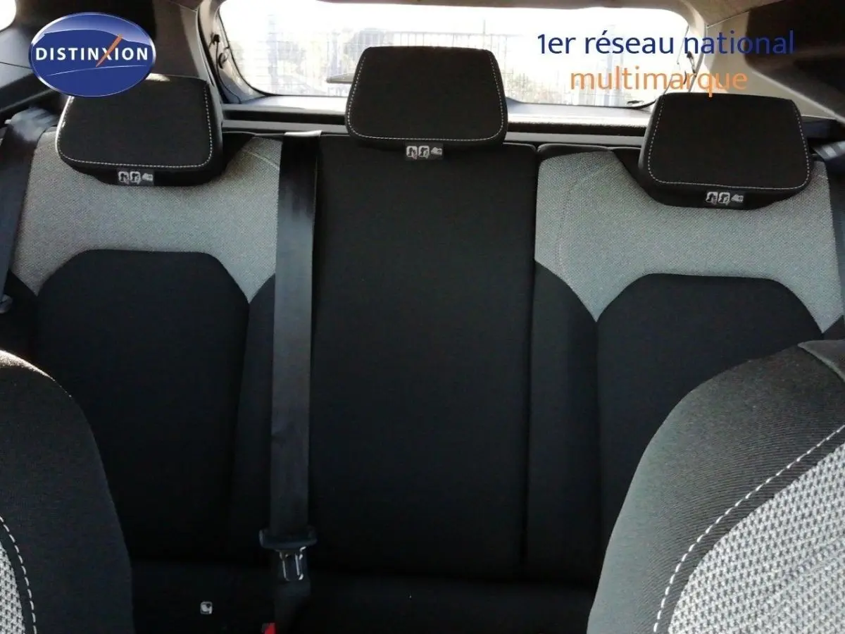Vue arrière intérieure du Dacia Duster 2026, sièges arrière en tissu noir et gris avec appuie-têtes et ceinture de sécurité centrale.