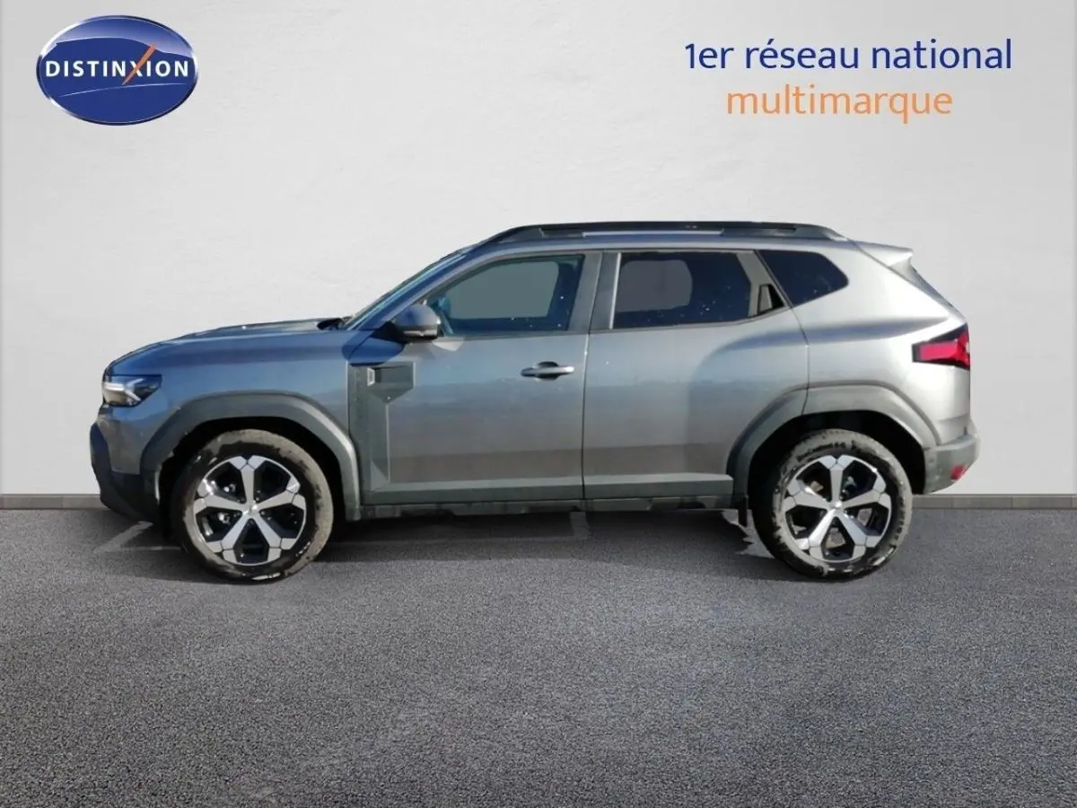 Profil droit du Dacia Duster TCE MHEV 140ch Journey gris schiste métal avec jantes bicolores et lignes robustes.