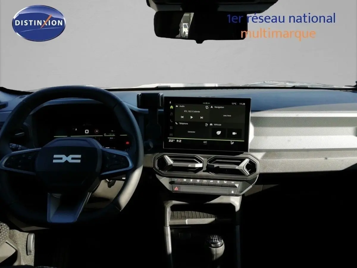 Vue intérieure du tableau de bord du Dacia Duster 2026, avec écran tactile central et volant multifonction noir.