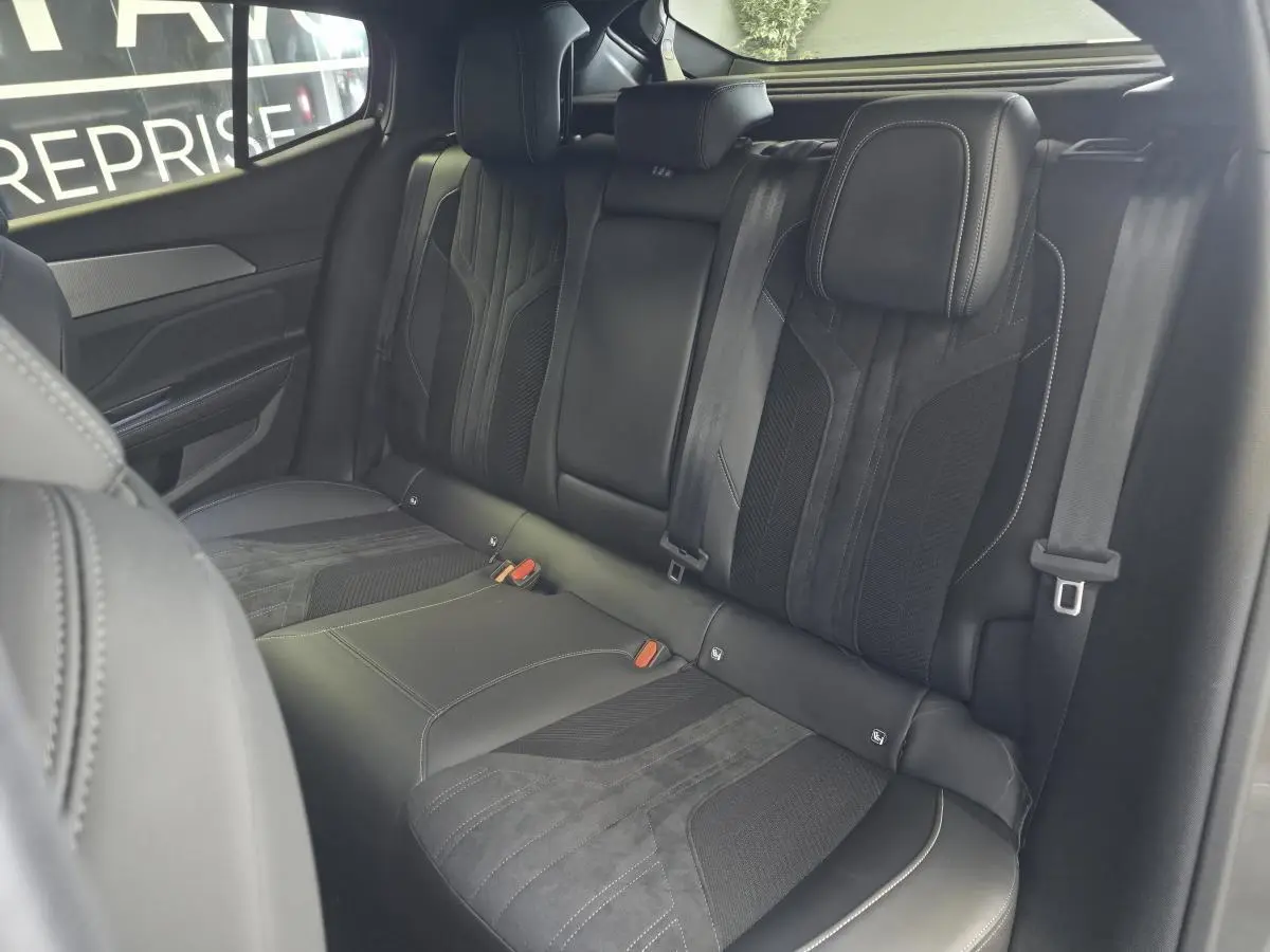 Vue intérieure sur la banquette arrière en sellerie tri-matière noire de la Peugeot 408 Berline GT 2024