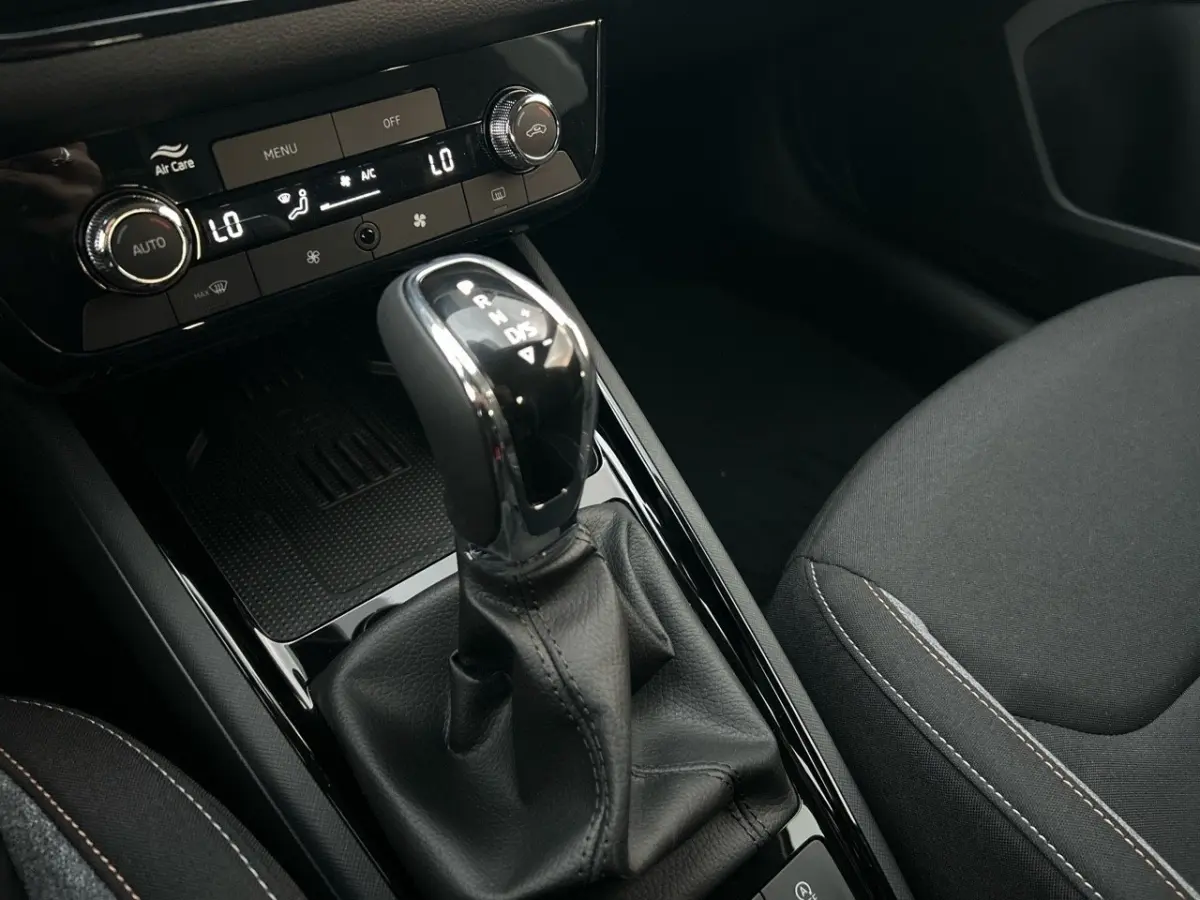 Le levier de vitesse automatique noir et chrome du Skoda Kamiq 2025, avec console centrale et siège tissu gris visible.