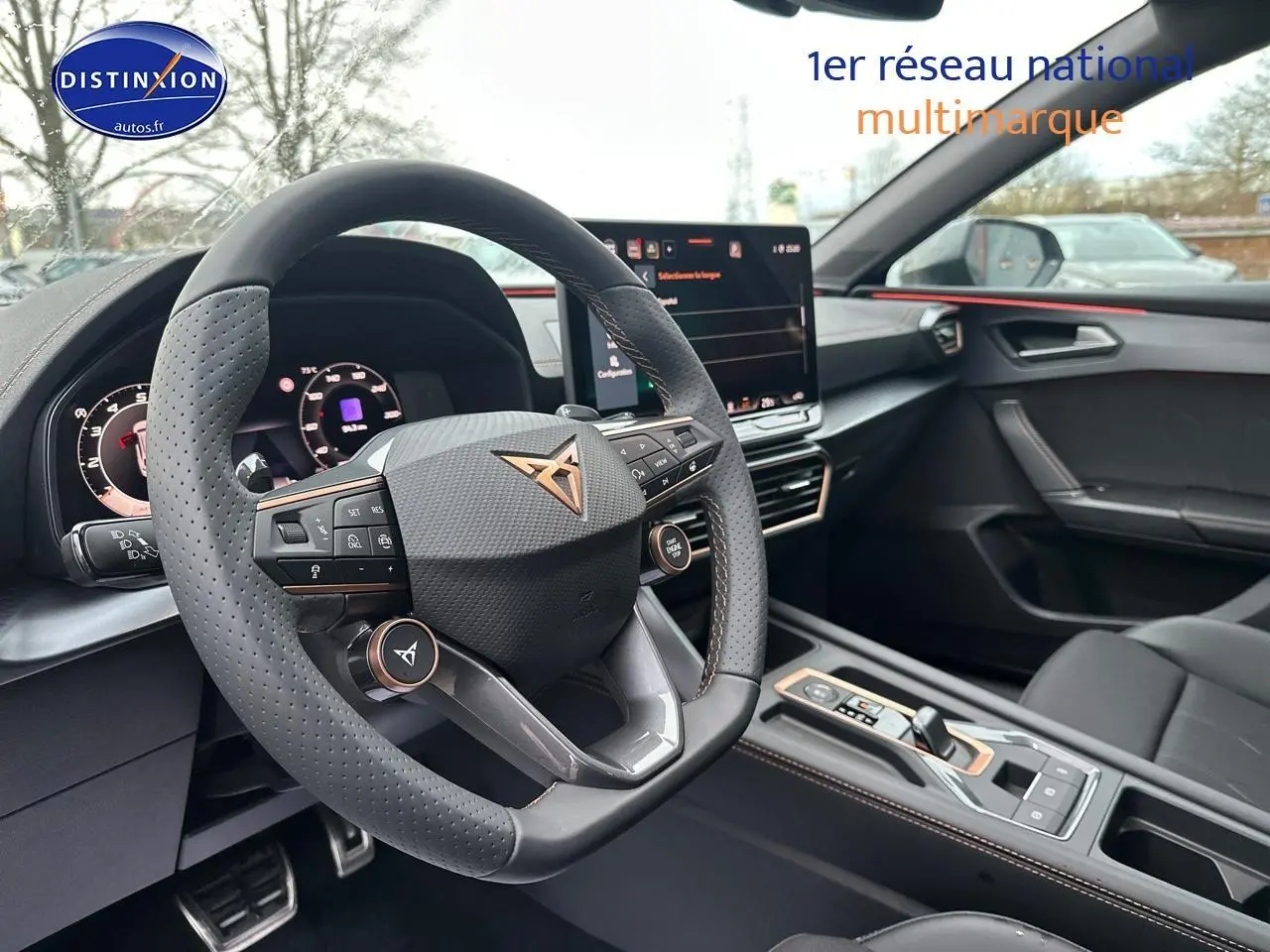 Intérieur de la CUPRA LEON ST 1.5 etsi hybrid 2025, vue du volant cuir perforé et écran tactile central.