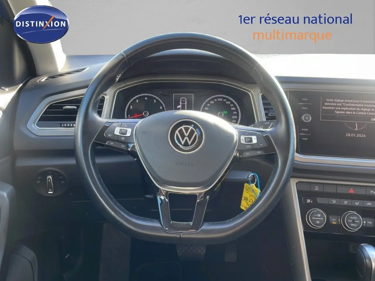 Vue intérieure centrée sur le volant noir du Volkswagen T-Roc 1.5 TSI 2021 avec tableau de bord et écran multimédia.