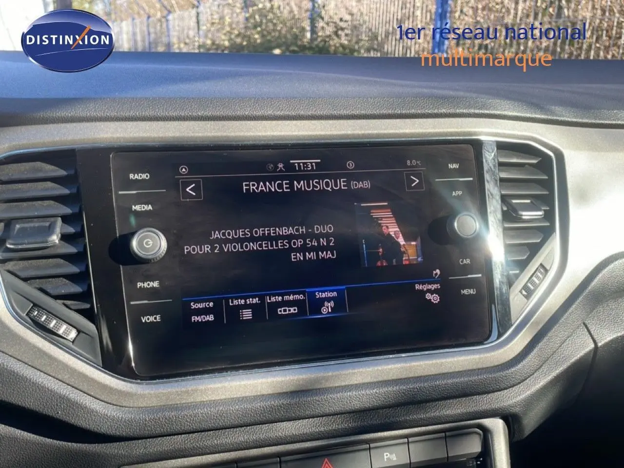 Écran tactile central du tableau de bord du Volkswagen T-Roc 1.5 TSI bleu, affichant une station radio France Musique.