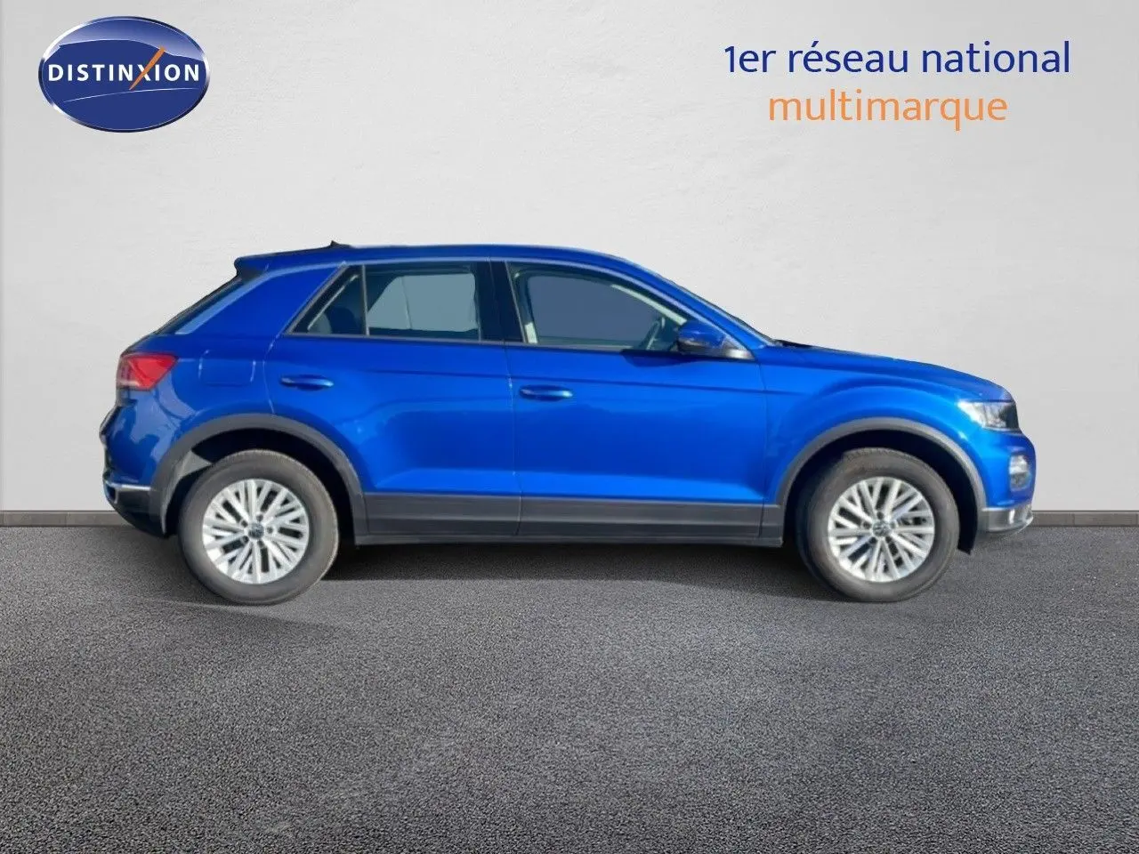 Profil droit d'un Volkswagen T-Roc bleu Ravenna métallisé, SUV compact avec jantes alliage et détails noirs.