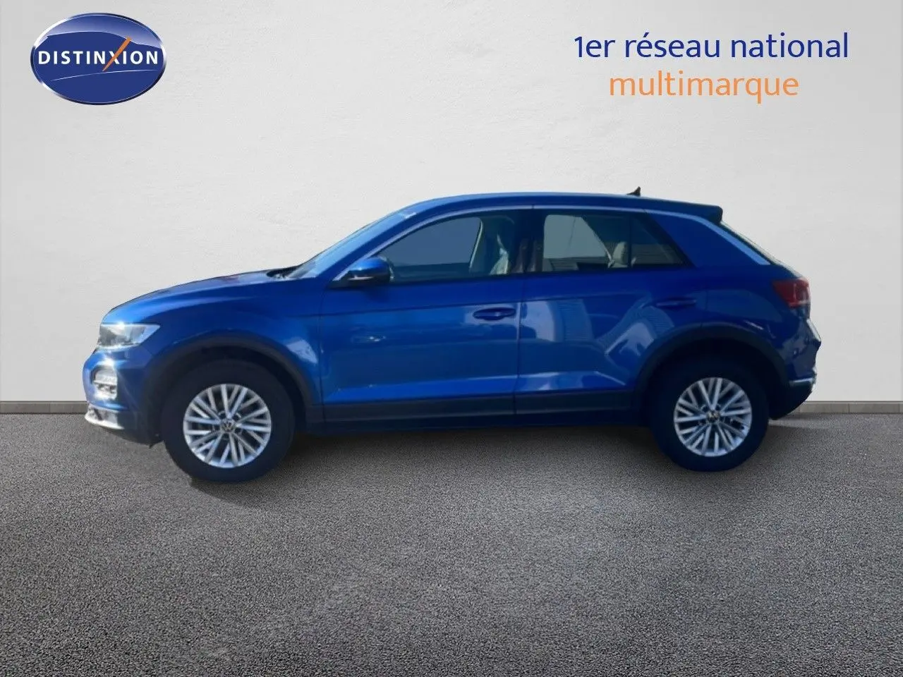 Vue de profil côté gauche d'un Volkswagen T-Roc bleu Ravenna métallisé, avec jantes alliage et carrosserie compacte.